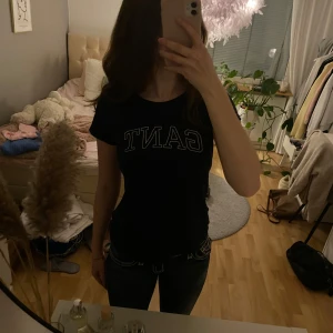 Marinblå t-shirt från GANT - Snygg marinblå t-shirt från GANT med vit logga på bröstet. Normal i storleken. Säljer då jag inte använder längre. Använd ett fåtal gånger.