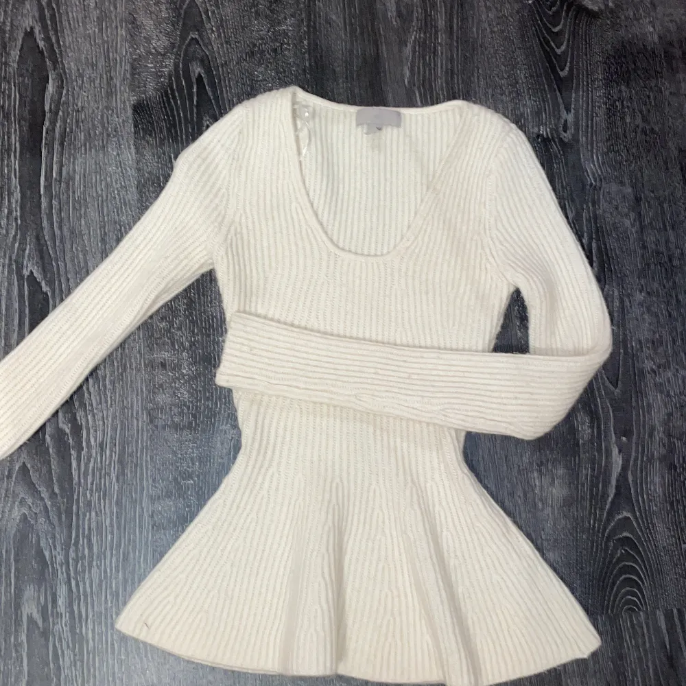 Säljer en stilren vit ribbad tröja från H&M. Tröjan har en v-ringad design och långa ärmar, perfekt för en chic och bekväm look. Passar utmärkt till både vardag och speciella tillfällen.. Neuletakit & Villapaidat.
