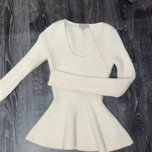 Vit ribbad tröja från H&M - Säljer en stilren vit ribbad tröja från H&M. Tröjan har en v-ringad design och långa ärmar, perfekt för en chic och bekväm look. Passar utmärkt till både vardag och speciella tillfällen.