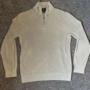 Mintgrön stickad tröja från H&M - Säljer en stilren mintgrön stickad tröja från H&M med dragkedja vid halsen. Tröjan har långa ärmar och ribbade muddar vid ärmslut och nederkant. Perfekt för kyliga dagar.