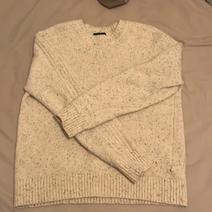 Beige stickad tröja - Säljer en beige stickad tröja från Jean Paul. Tröjan har en klassisk design med ribbstickade muddar och rund hals. Perfekt för kyliga dagar. Har ett pyttelitet hål men det är inget som märks. Står L men tröjan är cropped så sitter mer som M, möjligtvis S. Skriv vid funderingar.