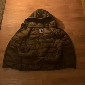 Svart dunväst från Jack & Jones - Snygg mörk grön dunväst från Jack & Jones med dragkedja och huva. Perfekt för kyligare dagar och enkel att matcha med andra plagg. Västen har en quiltad design och två praktiska fickor framtill.😄