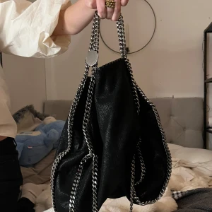 Stella McCartney Falabella väska - Snygg svart axelväska från Stella McCartney, den är i topp skick eftersom jag inte använder väskor så den har inte kommit till så mycket användning. Dustbag och äktighetsbevis kommer med väskan🥰 fick i present förra året. Nypris: 11000kr ungefär