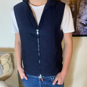 Oscar Jacobson väst  - Säljer nu denna riktigt snygga oscar Jacobson väst. Modellen på bilden är 177cm och väger 64kg. Västens storlek är XS/S då den är lite liten för modellen som brukar ha storlek S. Västen har även en nice innerficka som syns på bild 3. Vid funderingar är det bara att höra av sig.