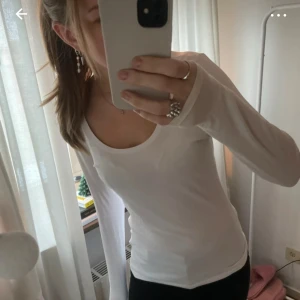 Vit långärmad topp - Säljer en stilren vit långärmad topp med rund halsringning. .