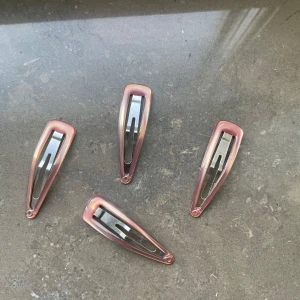 Rosa hårklämmor i metall y2k - Fyra stilrena hårklämmor i metall med en glansig rosa yta. Perfekta för att hålla håret på plats med stil.