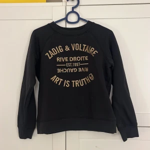 Svart tröja från Zadig & Voltaire - Snygg svart tröja från Zadig & Voltaire. Använd 1 gång, väldigt fint skick strl 14-S, Tröjan är liten i storleken!! Nypris: 2100kr💗!!