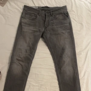 Grå jeans från Replay - Snygga grå jeans från Replay. De har en stilren look med Replay-logga på fickan och baksidan. Perfekta för en avslappnad stil.