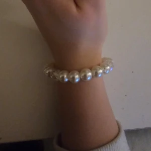 Pärlarmband med kristallpärlor - Elegant armband med vita pärlor och glittrande kristallpärlor. Perfekt för att ge en touch av elegans till din outfit. Armbandet är elastiskt och passar de flesta handleder.