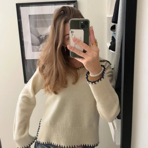 Jättefin stickad tröja  - Säljer en beige tröja med fina blåa kantdetaljer!! Tröjan har långa ärmar och en avslappnad passform. Skriv gärna om du har frågor eller är intresserad 🩵