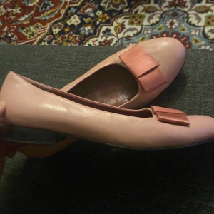 Rosa ballerinaskor med rosett - Snygga rosa ballerinaskor med en dekorativ rosett på ovansidan. Perfekta för en stilren look. Skorna har en platt sula och är bekväma att bära.