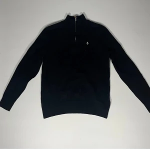 Svart tröja med dragkedja från Morris - Snygg svart tröja från Morris med dragkedja och en liten broderad detalj på bröstet. Perfekt för en stilren look. Tröjan är i nyskick. Det är en S men sitter som xs. Nypris är 1300. Pris kan diskuteras 