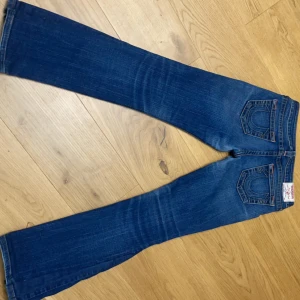 Blå jeans från True Religion - Midja 39cm Beninnerlängd 78 cm  Storlek 29 Låg midjade bootcut jeans(omsydda till bootcut)  Sista bilden visar där det sytts om
