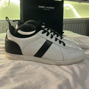 Svarta och vita sneakers från Dior -   Snygga sneakers från Dior i svart och vitt. Skorna är i princip i nyskick och har endast använts några enstaka gånger. Nypriset på skorna är runt 9000 kr.  Storleken är 42, men de kan definitivt passa upp till 44 om du tar ut den första sulan. Självklart är skorna äkta, och jag tar gärna emot byten mot andra skor eller plagg.  Har du några frågor? Jag besvarar dem gärna.  Med vänliga hälsningar, Oscar