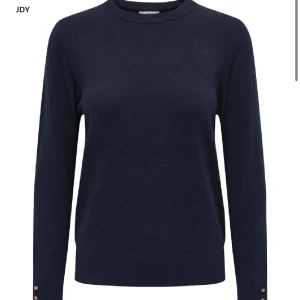 Mörkblå tröja med knappar - Elegant mörkblå tröja med långa ärmar och dekorativa knappar vid ärmsluten. Från Holly & white. Köpt för 350kr