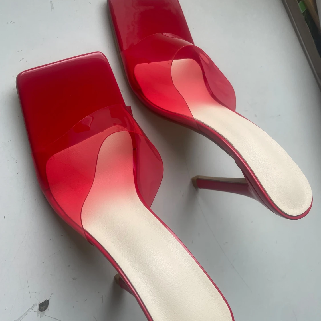 Röda klackskor med transparent rem