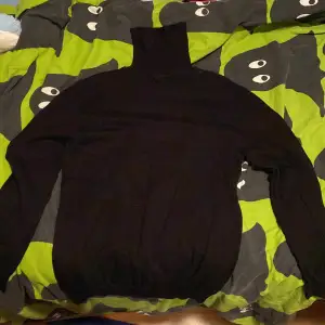 Säljer en stilren svart polotröja från Smog i storlek XS. Tröjan har en klassisk design med lång ärm och hög krage, perfekt för kyligare dagar. Passar bra till både jeans och chinos.