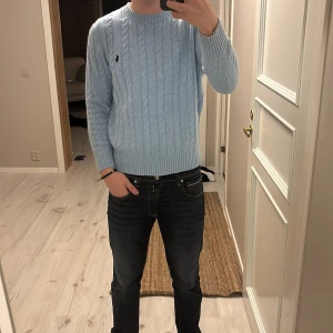 Ljusblå stickad tröja från Ralph Lauren - Säljer en stilren ljusblå stickad tröja från Ralph Lauren med kabelstickat mönster. Tröjan har långa ärmar och en rund halsringning. Perfekt för kyligare dagar. Använd ett fåtal gånger. Priset kan diskuteras. Kom dm för frågor☺️