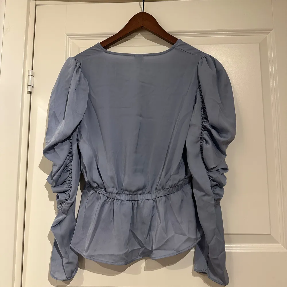Blå blus från ”visual Clothing project”. Skulle säga att den är lite ljusare i färgen än vad som framgår på bilderna. Inte mycket använd , fint skick! Storlek S. Puserot.