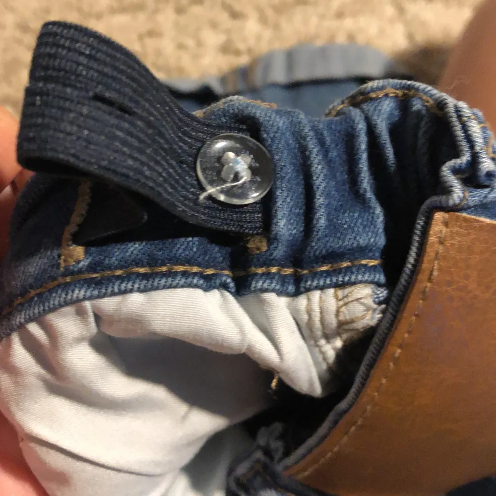 Säljer ett par blå jeansshorts med uppvikta ben. De har en elastisk midja med justerbar knapp för bättre passform. Shortsen har två framfickor och två bakfickor. Perfekta för sommaren!. Shorts.