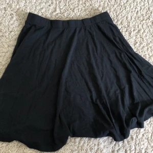 Svart kjol från SOC - Säljer en svart kjol från SOC i storlek 38 (M). Kjolen är enkel och stilren, perfekt för både vardag och fest. Den har en normal passform och är gjord av ett mjukt och bekvämt material. Passar bra till alla tillfällen!