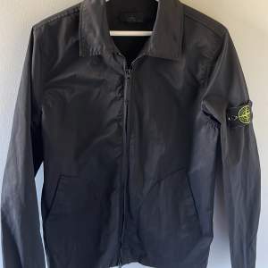 Säljer en snygg svart skjortjacka från Stone Island. Perfekt för vår och höst. Strl L men liten i storleken, passar 175-185. Materialet känns slitstarkt och bekvämt. Påse och digitalt kvitto finns!