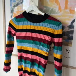 Färgglad randig tröja - Säljer en superfin färgglad randig tröja med långa ärmar. Tröjan har ett ribbat mönster och är perfekt för att liva upp vilken outfit som helst. Den är i nyskick och passar perfekt för höst och vår. Storleken är dam S