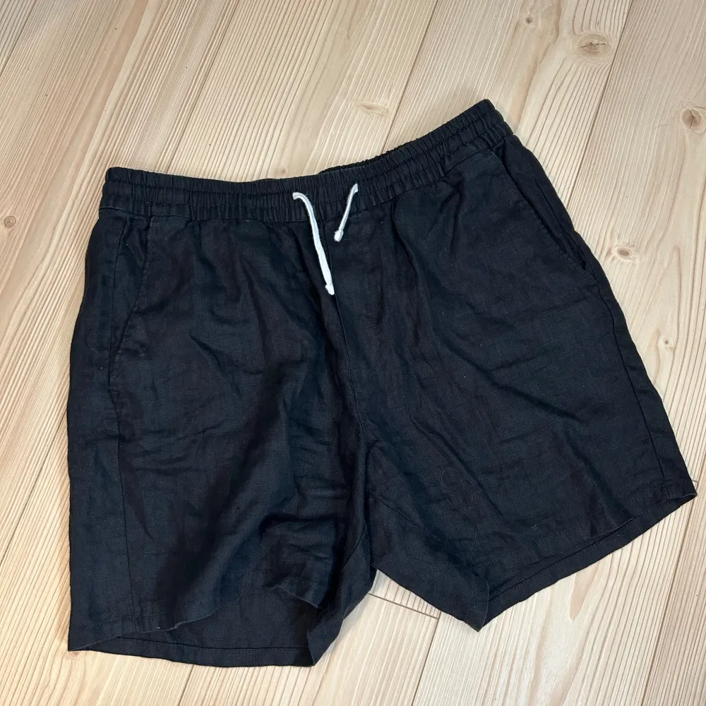 Säljer ett par svarta linneshorts från Weekday i storlek M. De är gjorda av ett bekvämt material och har en elastisk midja med en vit dragsko. använda ett fåtal gånger. pris går att diskuteras . Shorts.