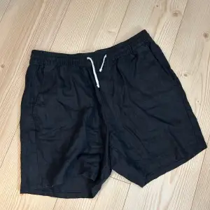 Säljer ett par svarta linneshorts från Weekday i storlek M. De är gjorda av ett bekvämt material och har en elastisk midja med en vit dragsko. använda ett fåtal gånger. pris går att diskuteras 