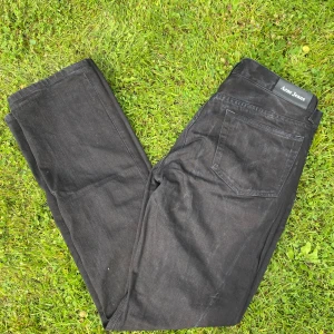 Svarta jeans från Acne Jeans - Säljer ett par svarta jeans från Acne Jeans i storlek 34/34. De är tillverkade av 100% bomull och har en klassisk rak passform. Perfekta för både vardag och fest! 🖤