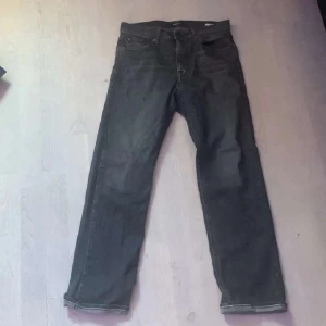 Svarta jeans från Replay - Säljer ett par svarta jeans från Replay i modellen Thad. De är i bra skick och har en klassisk femficksdesign med dragkedja och knapp. Perfekta för både vardag och fest!