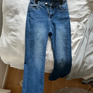 Blå jeans med dragkedja - Säljer ett par blå bootcut jeans med dragkedja och knappstängning. Dem är något högre i midjan. De har en snygg tvätt och ser riktigt bekväma ut. Perfekta för vardagsbruk! Passar mig som är 175!