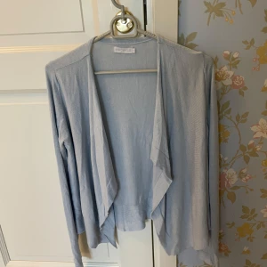 Blå kofta från Stockh LM - Jätte söt kofta från Stockh LM, köpt någon gång på sent 2000 tal eller tidigt 2010 tal. Skulle uppskatta att den även kan passa en S även om den officiella storleken är XS. I fint skick. Fråga gärna vid funderingar!❣️