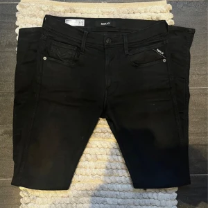 Replay Jeans svarta - Säljer ett par svarta replay anbass jeans i storlek 32  men passar större är själv 185 och de passar mig. Jeansen är i modellen anbass och sitter slim.