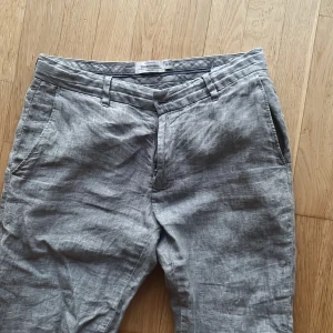 Grå linnebyxor fråm dressmann  - Snygga grå linnebyxor från Dressmann i färgen ljusgrå som är i bra skick. 