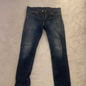 Levis 511 - Snygga blå jeansbyxor med en klassisk femficksdesign och knappgylf. De har en straight passform och är perfekta för en avslappnad stil. Jeansen har en lätt tvättad look som ger dem en cool och trendig känsla.