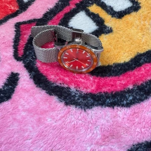 Orange gant klocka - Har en repa. Köptes för 1300kr för 2 år sen. Kan inget om klockor eller storleken. 