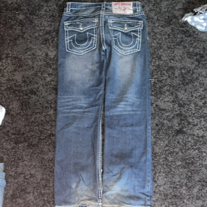 Blå jeans med kontrastsömmar - Snygga blå jeans med tydliga kontrastsömmar och klassisk femficksdesign. De har en rak passform och är perfekta för en avslappnad stil. Detaljer som knappar och slitningar ger en cool look. saknar en knapp, OBS: ACCEPTERA INTE TILLBAKA SKICKNINGAR 