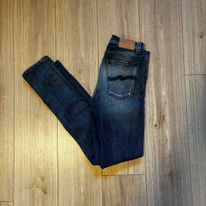 Mörkblå jeans från Nudie Jeans - Snygga mörkblå jeans från Nudie Jeans, jeansen är i bra skick och anvisning synd knappast. Nypris ligger på runt 1600kr, mitt pris 549. Hör av er vid intresse eller funderingar.
