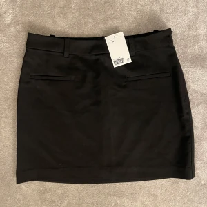 Svart minikjol - Svart minikjol med fickor framtill med prislapp kvar.