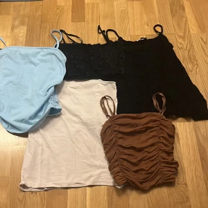 Fem olika linnen i olika färger och stilar - Säljer fem linnen: ett ljusblått med smala axelband, ett ljusrosa med smala axelband, ett svart spetslinne , en svart topp med ros mönster och ett brunt med rynkade detaljer. Perfekta för sommaren och kan matchas med olika outfits.