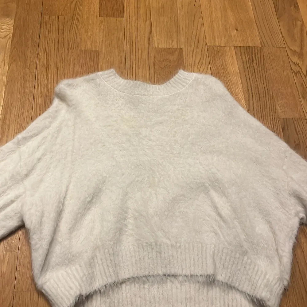 Mysig vit fluffig tröja från H&M. Perfekt för kyliga dagar med sin mjuka och varma känsla. Tröjan har en rund halsringning och ribbade kanter som ger en stilren look.. Neuletakit & Villapaidat.