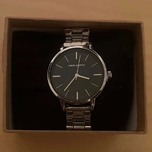 Klocka - Klocka med en minimal repa runt skärmen som knappt syns, annars i nyskick 