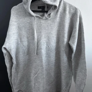 Grå hoodie från Amisu - Säljer en stilren grå hoodie från Amisu. Den är mjuk och bekväm med en klassisk huva och dragsko. Perfekt för en avslappnad look. Passar bra till jeans eller mjukisbyxor.