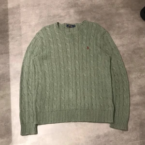 Grå/grön kabelstickad tröja från Ralph Lauren - Säljer en snygg grön kabelstickad tröja från Ralph Lauren.  |  Perfekt för kyligare dagar! |Storlek: S men passar även M.  |. Pris:389kr🤩 fantastiskt pris | Hör av er vid minsta fundering😊