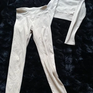 Beige ribbad set från H&M - Säljer ett snyggt beige ribbat set från H&M:s Divided-kollektion. Setet består av en croppad långärmad topp och matchande byxor. Perfekt för en stilren och bekväm look. Passar både till vardags och avslappnade tillfällen.