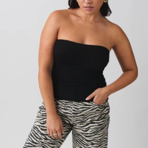 Svart tubtopp - Snygg svart tubtopp i ribbat material. Perfekt för en stilren look och kan enkelt matchas med olika outfits. Toppen är axelbandslös och har en tight passform. Endast provat aldrig använd!🖤