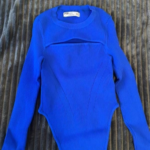 Blå ribbad body - Snygg blå ribbad topp från new yorker oanvänd med unik design och långärmad stil. Perfekt för att sticka ut med sin coola look. Passar bra till både jeans och kjol. 💙