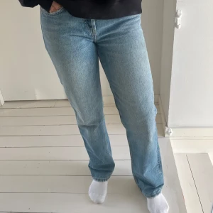 Blå jeansbyxor - Snygga blå jeansbyxor med en klassisk straight passform. De har en hög midja och är perfekta för en avslappnad stil. Byxorna har en dragkedja och knapp framtill samt fem fickor.