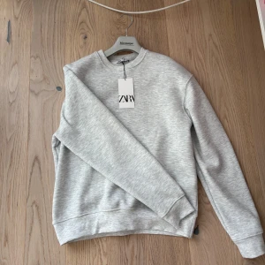 Grå sweatshirt från Zara - Säljer en stilren grå sweatshirt från Zara i storlek s. Tröjan är helt ny och aldrig använd köpt för 349kr. För fler frågor/bilder tveka inte på att skriva!